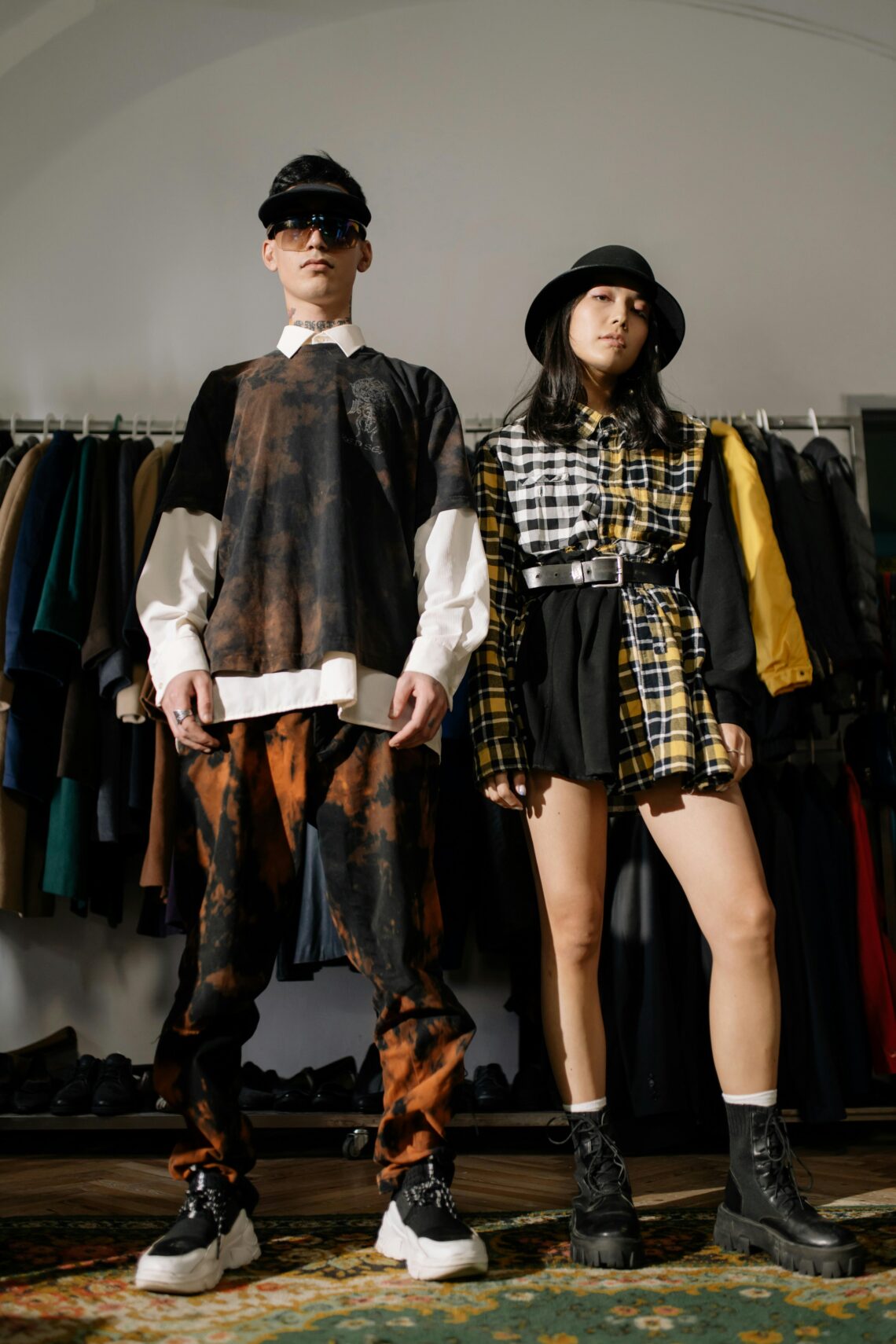 Two individuals pose confidently in a vintage clothing store showcasing urban fashion style.